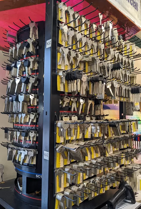 A key rack displaying many keys on a drum and on the side of the rack ready for key duplication.